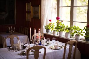 a dining room table with candles and plants on it at Nutheim Gjestgiveri in Flatdal