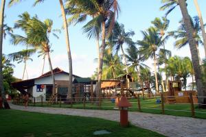 un parc avec une aire de jeux et des palmiers dans l'établissement Serrambi Resort, à Porto de Galinhas