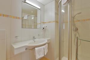 ein weißes Bad mit einem Waschbecken und einer Dusche in der Unterkunft Gästehaus Hoamatl in Mayrhofen
