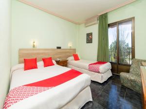 a hotel room with two beds and a chair at Hotel El Prado by Vivere Stays in Carrascosa del Campo