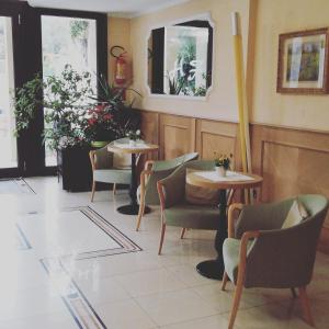 a restaurant with two tables and chairs and plants at Hotel Fioroni in Bellagio