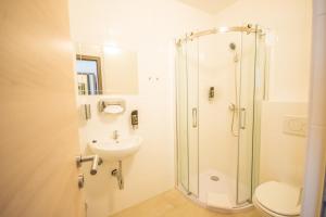 łazienka z prysznicem, toaletą i umywalką w obiekcie Hotel Turmfalke 24H Check In w Linzu