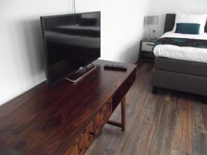 sala de estar con TV y cama en Hotel Bed & Breakfast De Poffert en Borger