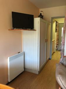 een woonkamer met een koelkast en een flatscreen-tv bij APPARTEMENT 804 in Le Dévoluy