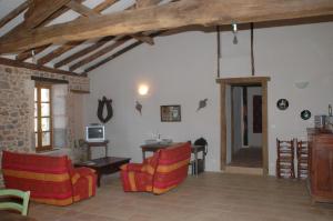 a living room with couches and a table and a room with a tablektop at Villa Gites Chambre d hôtes avec piscine Dordogne 2-4-6-8-10 personnes in Bussière-Badil