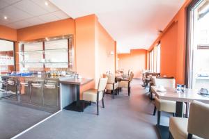 jadalnia ze stołami i krzesłami w restauracji w obiekcie Hotel Turmfalke 24H Check In w Linzu