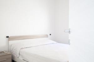 łóżko w białej sypialni z białymi ścianami w obiekcie Airone Residence w mieście Zambrone
