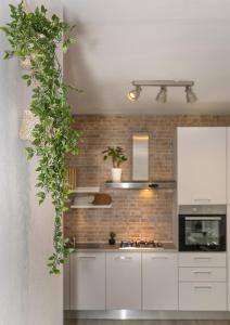 a kitchen with white cabinets and a brick wall at BB L'APPRODO in Pisa