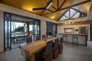a kitchen and dining room with a large wooden table at The Beach House in Batukaras