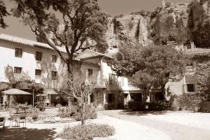 une photo en noir et blanc d'un bâtiment et d'arbres dans l'établissement Le Manoir, à Mornas