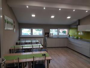 a room with tables and chairs and a kitchen at Budziechów Noclegi in Lubsko