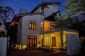 a white house at night with lights at Amuththa Resort in Anuradhapura