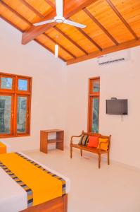 a bedroom with two beds and a ceiling fan at Amuththa Resort in Anuradhapura