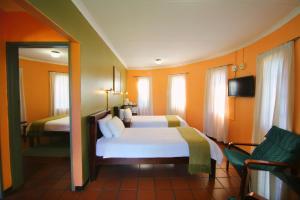 a hotel room with two beds and a tv at Kalahari Arms Hotel in Khemsbok