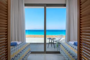 a bedroom with a view of the ocean from a balcony at Avra Beach Resort in Ixia