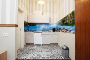 a kitchen with white cabinets and a painting on the wall at Design Apartments 2 in Dortmund