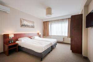 Een bed of bedden in een kamer bij Arass Hôtel & Business Flats