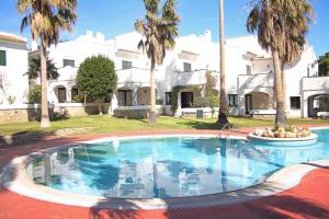 a swimming pool in front of a house with palm trees at Beautiful seafront house in Hospitalet de l'Infant