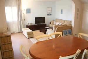 un soggiorno con tavolo e divano di Beautiful seafront house a Hospitalet de l'Infant