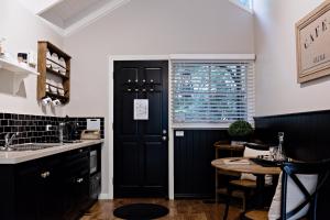 a kitchen with a black door and a table at Belle Le Vie in Sassafras