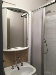 een badkamer met een wastafel en een douche met een spiegel bij STUDIO 801 in Le Dévoluy