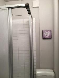 een badkamer met een douche, een toilet en een hartfoto bij STUDIO 801 in Le Dévoluy