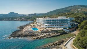 a large white building with a blue ocean view at Grupotel Aguait Resort & Spa - Adults Only in Cala Ratjada