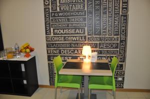 a dining room with a table and green chairs at Letto & Riletto in Montecassiano