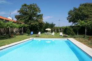ein Swimmingpool in einem Hof mit Tisch und Stühlen in der Unterkunft Quinta de Santa Baia in Gaifar