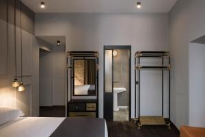 a bedroom with a bed and a sink and a mirror at Chapter Roma in Rome