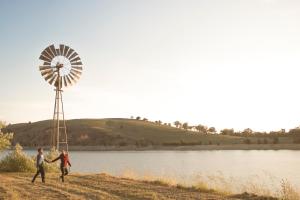 duas pessoas a passar por um moinho de vento ao lado de um lago em Good Hope Resort em Good Hope