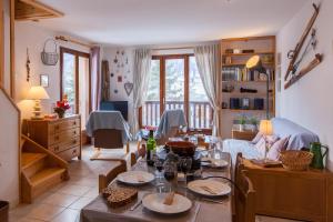 a living room with a table and chairs in it at Le Rocher chalet mitoyen 9 couchages by Mountain Collection Immobilier in Le Monêtier-les-Bains