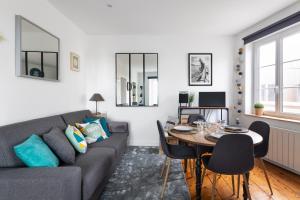 een woonkamer met een bank en een tafel bij Le Plongeoir by Cocoonr in Saint-Malo