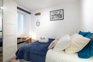 a bedroom with a bed with blue sheets and white pillows at Le Plongeoir by Cocoonr in Saint Malo