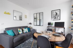 een woonkamer met een bank en een tafel bij Le Plongeoir by Cocoonr in Saint-Malo +9 foto's