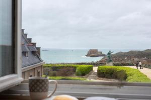 a window with a view of the ocean and a statue at Le Plongeoir by Cocoonr in Saint Malo