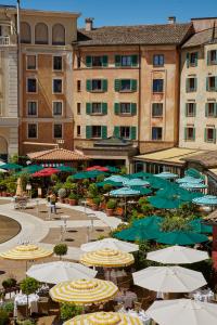 a large group of umbrellas and tables and buildings at 4-Sterne Superior Erlebnishotel Colosseo, Europa-Park Freizeitpark & Erlebnis-Resort in Rust