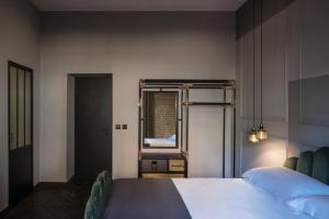 a bedroom with a large bed and a mirror at Chapter Roma in Rome
