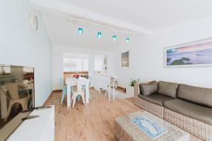 una sala de estar con un sofá y una mesa en Paul do Mar Beach House, en Paul do Mar