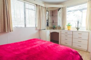 um quarto com um cobertor vermelho numa cama em OW Mikomania em Charzykowy
