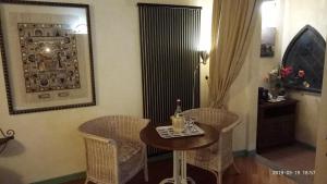 Habitación con mesa, sillas y botella de vino. en Casa del Sole, en Venturina Terme