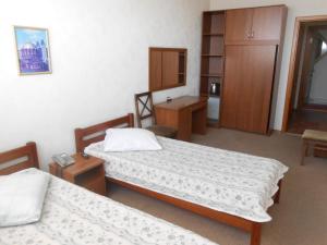 a hotel room with two beds and a desk at Naberezhnaya in Novosibirsk