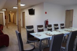 einen Konferenzraum mit einem weißen Tisch und Stühlen in der Unterkunft Penzion - Peri in Hokovce