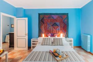 een blauwe slaapkamer met een bed met een wandtapijt bij Casa Solares in Solfara Mare