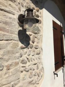 uma luz no lado de uma parede de pedra em La cantinetta em Goito