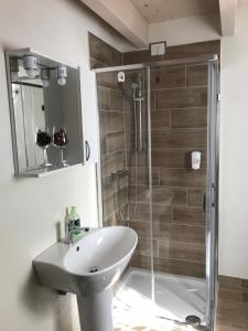 bagno con lavandino bianco e doccia di B&B La Piazzetta a Goito Altre 37 foto