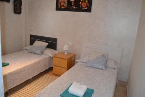 um quarto com 2 camas e uma mesa com um candeeiro em Salou apartamento cerca de playa y zona turística em Salou