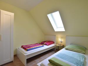 ツィローにあるIdyllisches Ferienhaus mit überdachter Terrasseの屋根裏のベッドルーム(ベッド2台、天窓付)