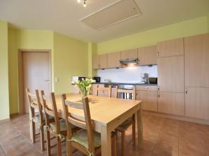 a kitchen with a wooden dining table and chairs at Gruppenurlaub im Ferienhaus in Zierow für 12 Gäste in Zierow