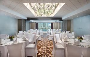 a banquet hall with white tables and chairs and a skylight at Gulf Court Hotel Business Bay in Dubai